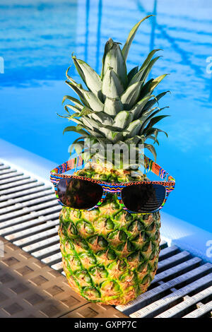 L'Ananas portant des lunettes de soleil à la piscine aux beaux jours Banque D'Images