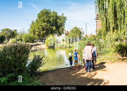 Une famille nourrir les canards sur la commune dans Barnes, à l'ouest de Londres, Royaume-Uni Banque D'Images