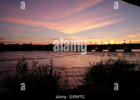 Pont de Pierre Bordeaux sur garonne au coucher du soleil avec des gens de manger dans le café du Port Banque D'Images