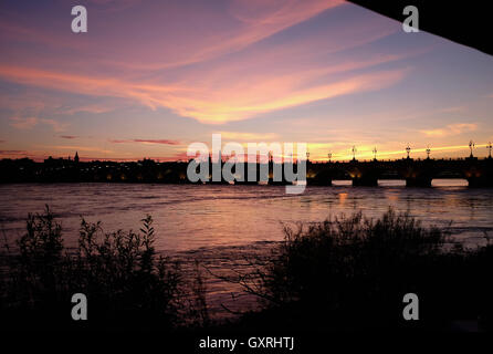 Pont de Pierre Bordeaux sur garonne au coucher du soleil avec des gens de manger dans le café du Port Banque D'Images