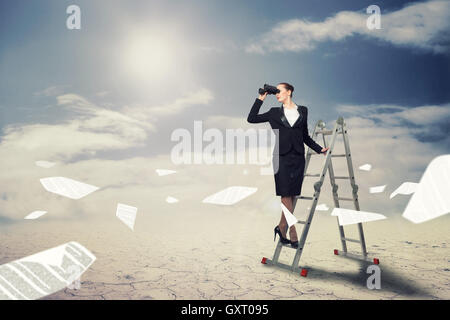 Businesswoman looking through binoculars Banque D'Images