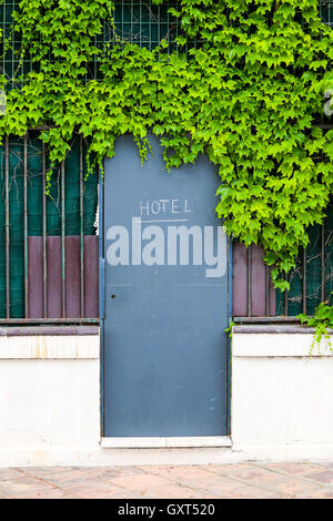 Entrée de l'hôtel porte à ouvrir une clôture avec le feuillage vert Banque D'Images