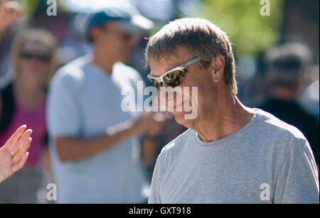 Homme sourit à Boulder Hometown Festival. Les ombres des danseurs reflète dans ses lunettes Banque D'Images