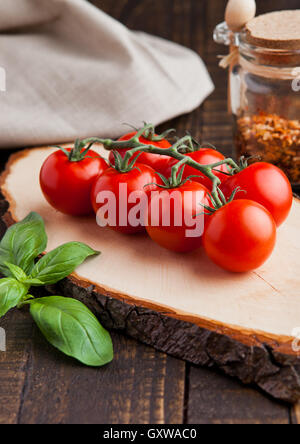 Les tomates fraîches avec le basilic et les épices sur fond de bois grunge jar Banque D'Images