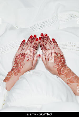 Fille, c'est main dans la main avec des tatouages au henné sur robe blanche Banque D'Images