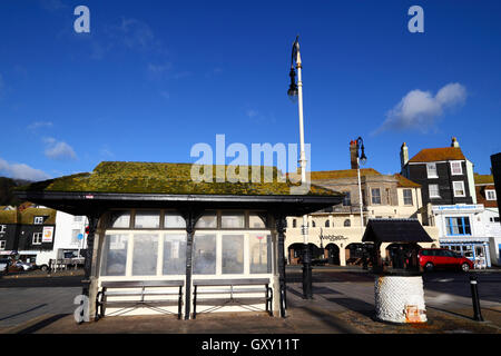 Old fashioned abri bus et qui souhaitent bien sur front de mer sur la vieille ville, Hastings, East Sussex, Angleterre Banque D'Images