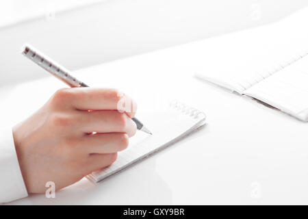 Woman's hand writing entrées dans un ordinateur portable Banque D'Images