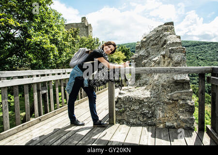 Jeune voyageur brunette woman posing in ruines du château de Hainburg an der Donau, Autriche. L'architecture ancienne. Banque D'Images