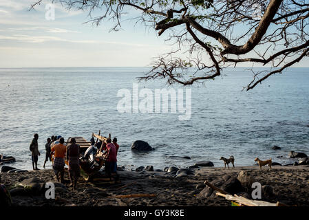 Pêcheurs traditionnels poussant le bateau de pêche sur la mer. Village de Lamalera, Lembata, Indonésie. Banque D'Images