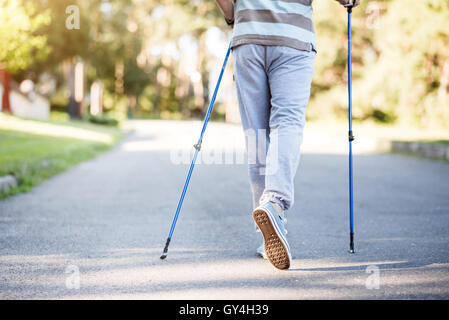 Man Walking in park lentement tout en utilisant des bâtons sprinter Banque D'Images