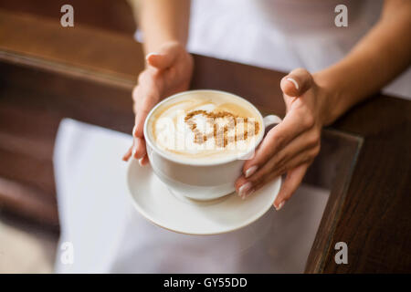 Mains de mariée avec latte art tasse à café. Selective focus, close-up Banque D'Images