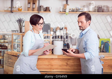 Deux propriétaires de petites entreprises dans les aires de l'article in cafe Banque D'Images