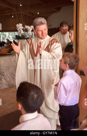 Habillé de façon formelle des enfants de race blanche d'origine hispanique et socialiser avec un diacre et un monseigneur avant de participer à une messe de Première Communion à Laguna Niguel, CA, l'église catholique. La première Communion est une cérémonie dans certaines traditions chrétiennes au cours de laquelle une personne Banque D'Images