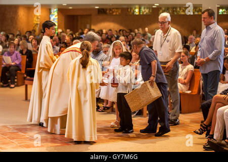 L'église marque le jour de collecte dans des paniers pour le monseigneur d'un Laguna Niguel, CA, l'Église catholique au cours d'une messe de Première Communion. La première Communion est une cérémonie dans certaines traditions chrétiennes au cours de laquelle une personne reçoit d'abord l'Eucharistie. Remarque Banque D'Images