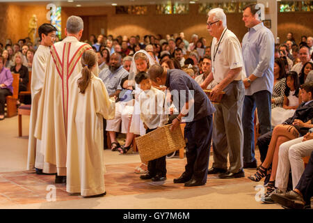 L'église marque le jour de collecte dans des paniers pour le monseigneur d'un Laguna Niguel, CA, l'Église catholique au cours d'une messe de Première Communion. La première Communion est une cérémonie dans certaines traditions chrétiennes au cours de laquelle une personne reçoit d'abord l'Eucharistie. Remarque Banque D'Images