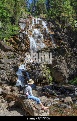 randonneur se relaxant sous les chutes de morrell dans la forêt nationale de lolo près du lac seeley, montana Banque D'Images