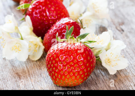 Fraises rouges et de fleurs sauvages sur fond de bois Banque D'Images