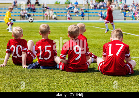 Children's Soccer Match de football. Réserver Joueurs de football sur un banc de l'équipe. Les enfants jouent au soccer jeu. Groupe d'enfants Soccer Plateau