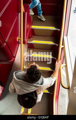 Les passagers monter monter à pied de l'escalier / mesures d'escalier, sur un bus à impériale Routemaster bus au pont supérieur Banque D'Images