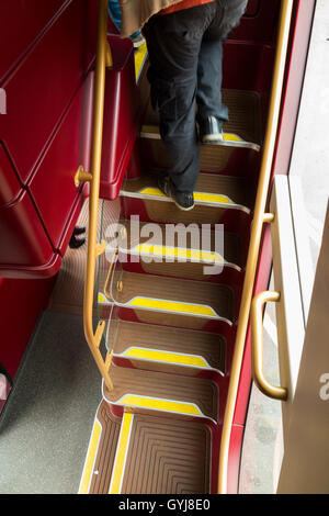 Les passagers monter monter à pied de l'escalier / mesures d'escalier, sur un bus à impériale Routemaster bus au pont supérieur Banque D'Images