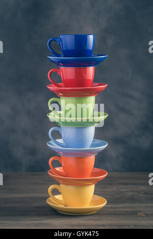 Pile de six tasses multicolores sur table Banque D'Images
