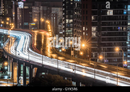 Des traînées de lumière brillante et une autoroute Gardiner humide que le trafic ne s'arrête jamais. Des pluies et chaude nuit d'été à Toronto au bord du lac. Banque D'Images