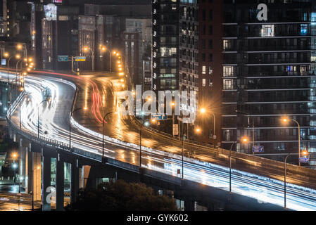 Des traînées de lumière brillante et une autoroute Gardiner humide que le trafic ne s'arrête jamais. Des pluies et chaude nuit d'été à Toronto au bord du lac. Banque D'Images