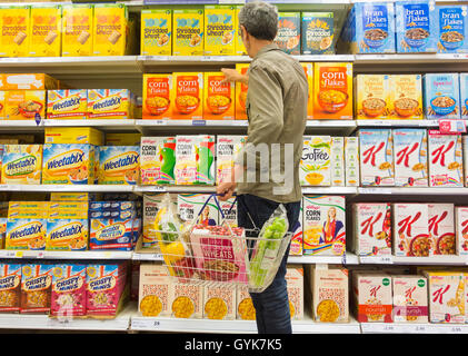 Homme acheter des céréales pour petit-déjeuner dans un supermarché Tesco. UK Banque D'Images