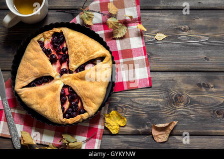 Cherry fait maison et tarte aux pommes sur fond en bois rustique avec des feuilles jaunes, copy space - Pâtisserie automne délicieux Banque D'Images