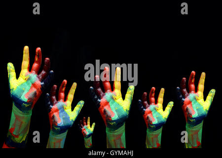 Les enfants de l'aide à la recherche d'Handss concept SOS sur fond noir. Banque D'Images