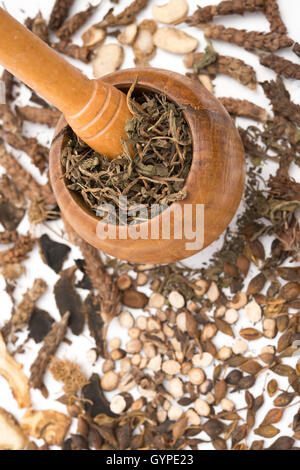 Mortier et pilon en bois vertical avec des herbes Banque D'Images