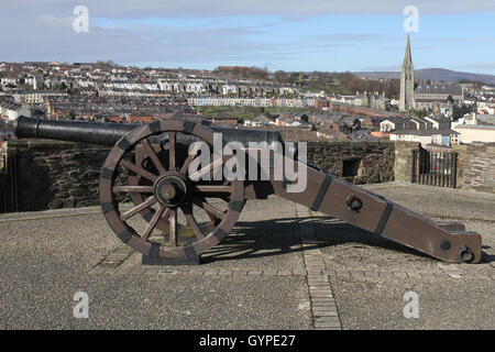 Cannon sur les murs de Londonderry, Irlande du Nord, donnant sur le Bogside de la ville. Banque D'Images