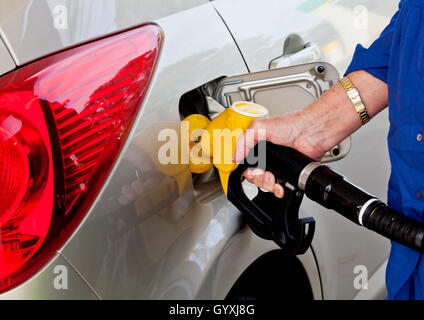 Femme à sa voiture de ravitaillement gas station Banque D'Images