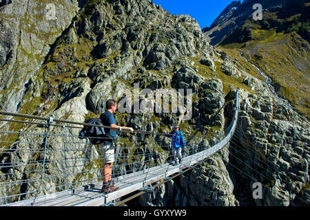 Les randonneurs traversant le bridgeTrift suspension pont sur la gorge de Trift, Gadmen, canton de Berne, Suisse Banque D'Images