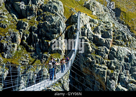 Les randonneurs traversent la Trift Pont suspendu Pont sur la gorge de Trift, Gadmen, canton de Berne, Suisse Banque D'Images