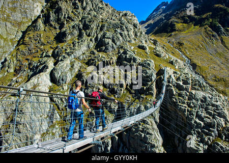 Les randonneurs traversant le bridgeTrift suspension pont sur la gorge de Trift, Gadmen, canton de Berne, Suisse Banque D'Images