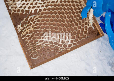 Traîneaux cassés, plateaux et autres morceaux d'ordures jonchent les amphithéâtre romain de Cirencester, Gloucestsershire Uk. Les articles ont été laissés après des jours de la luge et jouer dans la neige, laissant le domaine à la recherche comme un champ de bataille. Banque D'Images