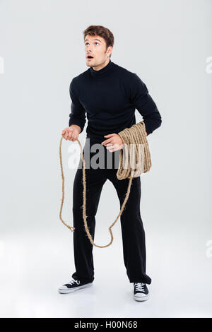 Toute la longueur du jeune homme surpris avec une corde et permanent jusqu'à la Banque D'Images