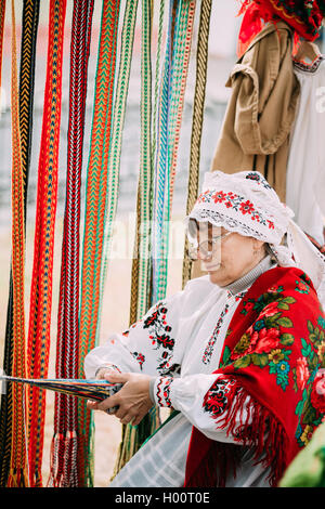 Gomel, Bélarus - 12 septembre 2015 : Femme en costume folklorique biélorusse national ceinture tissage Banque D'Images