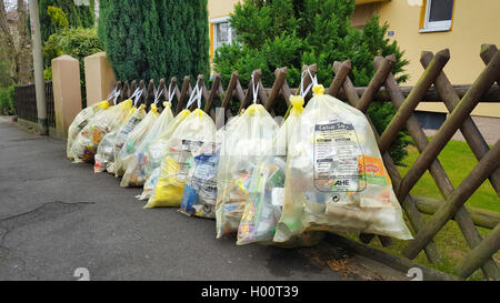 Rangée de sacs jaune accroché à une clôture rustique, Allemagne Banque D'Images