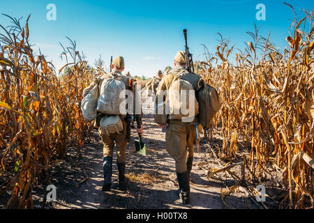 Groupe d'interprètes historiques non identifiés habillés en soldats russe soviétique va le long de la route sur le terrain. Banque D'Images