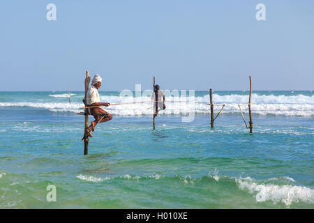 UNAWATUNA, SRI LANKA - 9 mars 2014 : les pêcheurs sur échasses à Unawatuna. Bon nombre de ces pêcheurs de gagner plus d'argent se faisant passer pour les touristes Banque D'Images