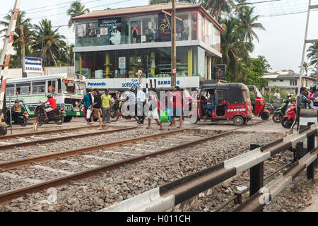 HIKKADUWA, SRI LANKA - le 22 février 2014 : les piétons et véhicules sur rail crossing. Les trains sont très bon marché et mal entretenu Banque D'Images