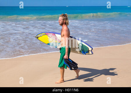 UNAWATUNA, SRI LANKA - 6 mars, 2014 : Jeune homme marche sur une plage de sable de planche de surf. Unawatuna est bien connu entre tourisme Banque D'Images