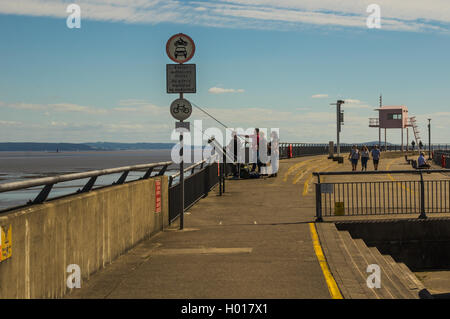 Le yachtmaster rose cabane sur la digue de barrage de la baie de Cardiff, les pêcheurs en mer Pêche à la chaîne avec des promeneurs au loin. Banque D'Images