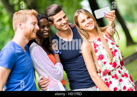 Groupe de jeunes et des couples en tenant vos autoportraits en nature et smiling Banque D'Images