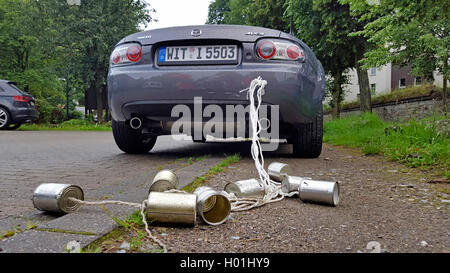 Boîtes de conserve vides sont liés avec de la ficelle à la voiture du couple, Allemagne Banque D'Images