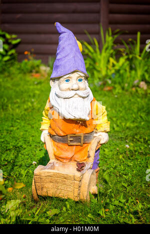 Nain de jardin avec une brouette dans le jardin familial Banque D'Images
