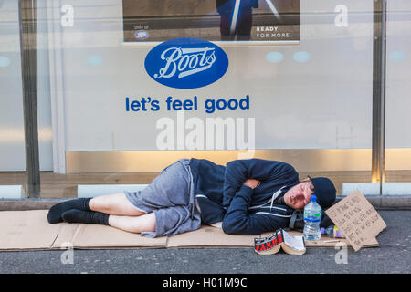 L'Angleterre, Londres, Oxford Street, les sans-abri Man Sleeping on Sidewalk Banque D'Images