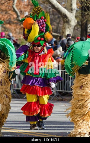 Un clown vêtu d'un costume de style Carmen Miranda avec coiffe fruits promenades dans le Macy's Thanksgiving Day Parade, New York. Banque D'Images